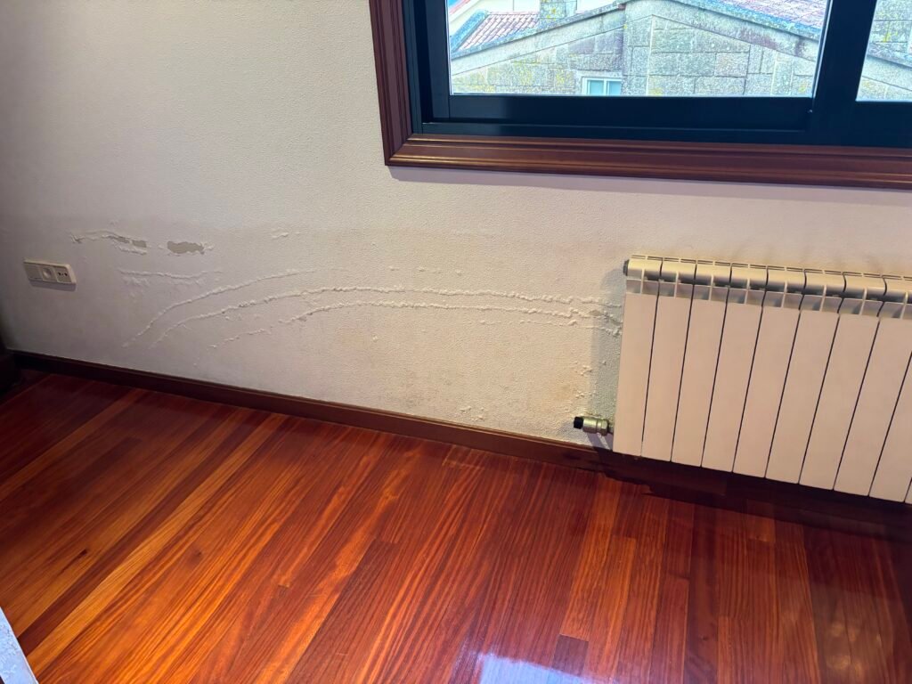 Humedad en pared en Pontevedra provocada por fuga de agua en calefacción
